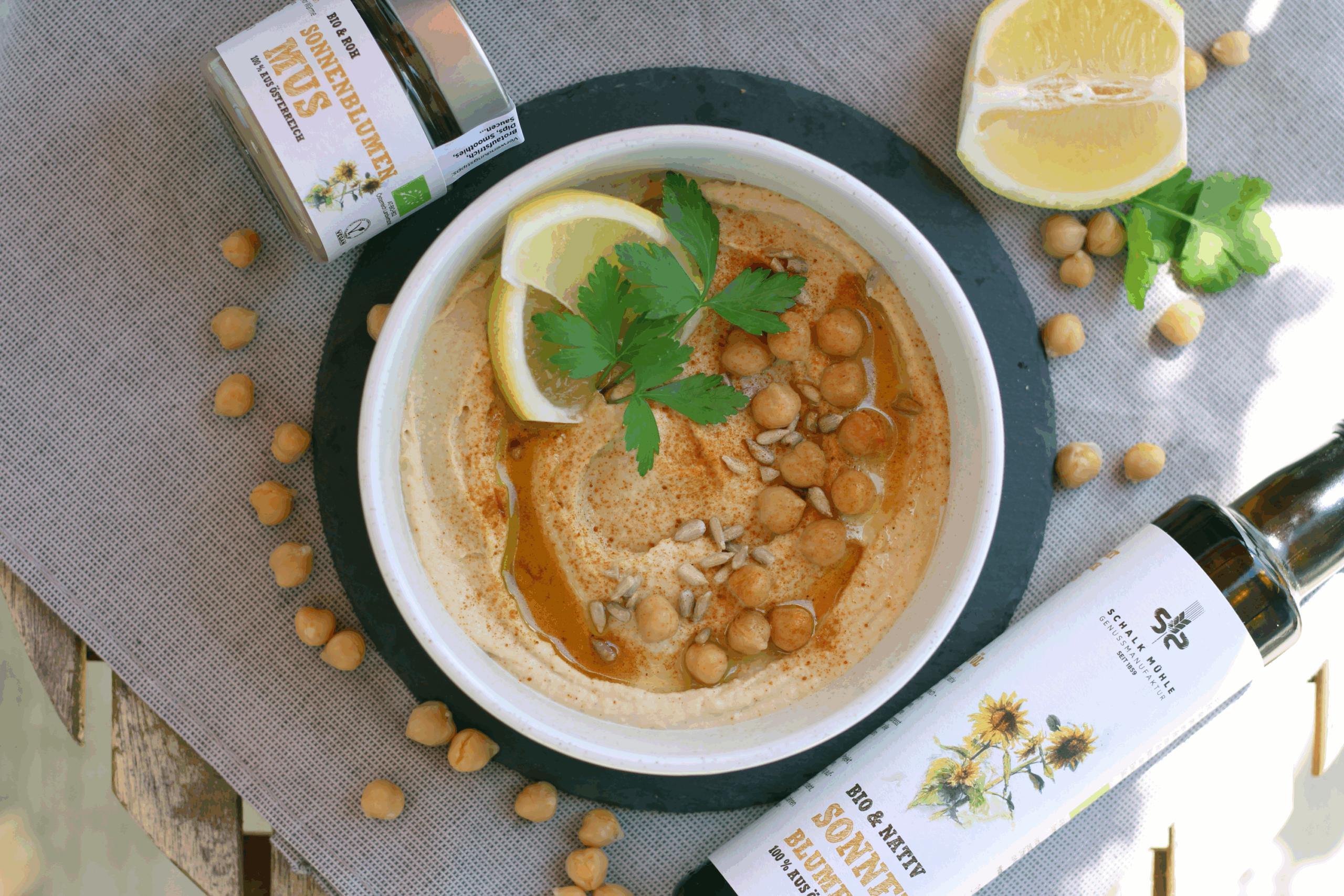Sonnenblumen-Hummus mit Kichererbsen, Zitrone und Petersilie, daneben Schalk Mühle Sonnenblumenmus