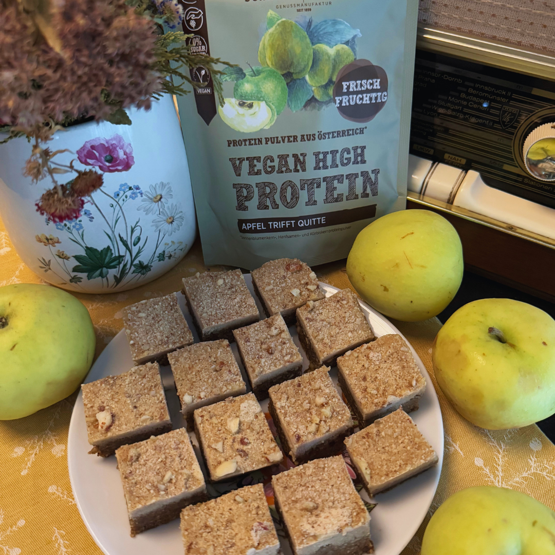Apfel-Nuss-Protein-Schnitten auf einem Teller mit Äpfeln neben Schalk Mühle Vegan High Protein Apfel trifft Quitte