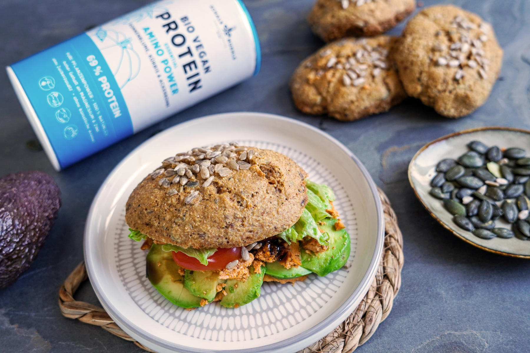 Protein-Weckerl mit Avocado, Tomate und Salat neben Schalk Mühle Bio Vegan Protein Amino Power
