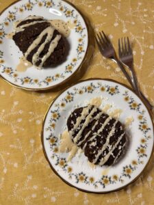 Schoko-Bananenbrot-Cookies mit heller Glasur und Kokos auf zwei Blumentellern