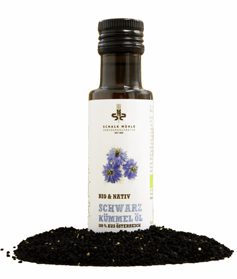 Schalk Mühle Bio Schwarzkümmelöl nativ, Flaschen-Vorderseite mit Blüten-Illustration, davor schwarze Kümmelsamen