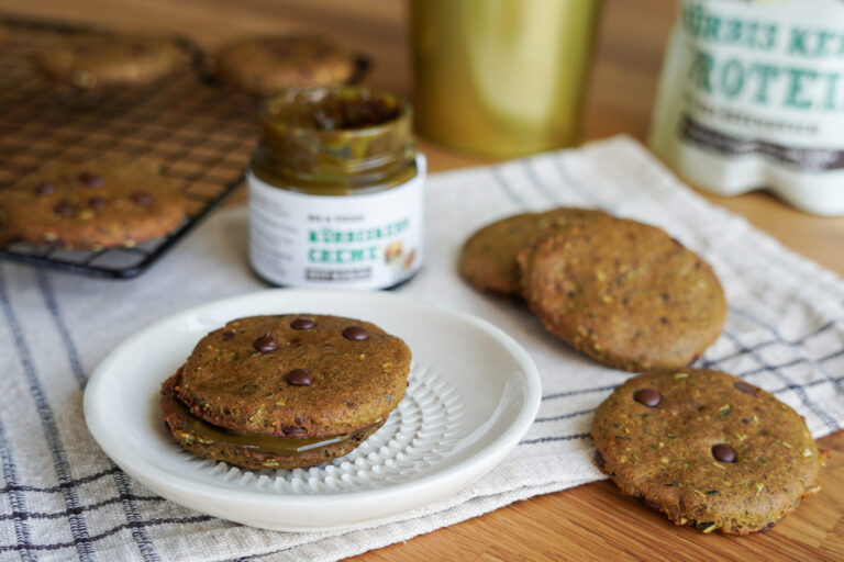Kürbiskern-Cookies mit Schokotropfen und Creme gefüllt, dahinter Schalk Mühle Kürbiskernprotein