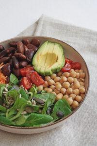 Gemüsebowl mit Bohnen, Avocado, Kichererbsen, Tomaten, Vogerlsalat und Kernen