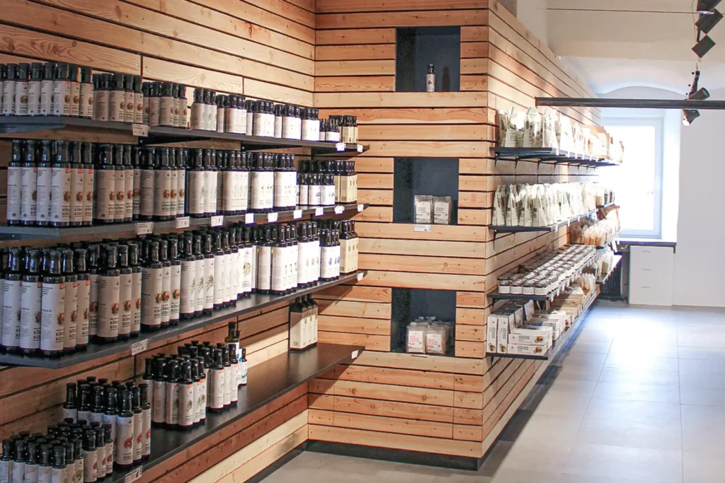 Wooden shelves in the farm shop with rows of pumpkin seed oil bottles and kernels