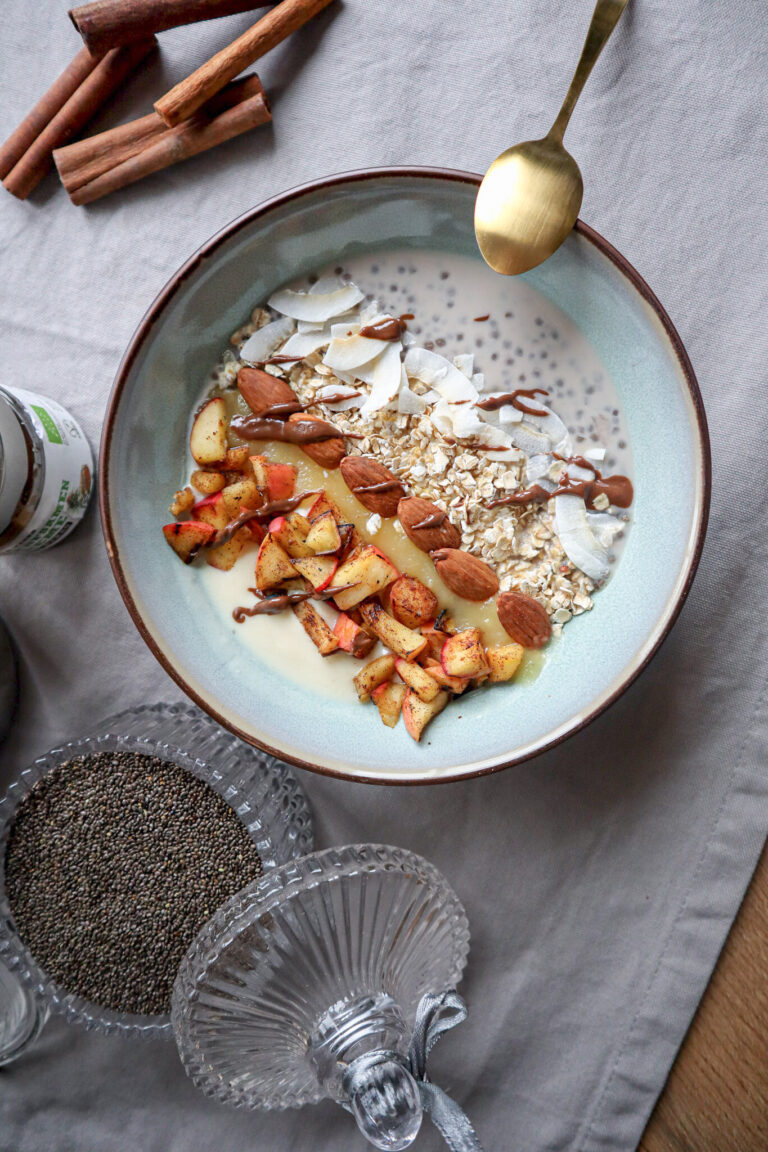 Frühstücksbowl mit Chia, Haferflocken, Zimtapfel, Kokoschips und Mandeln von oben