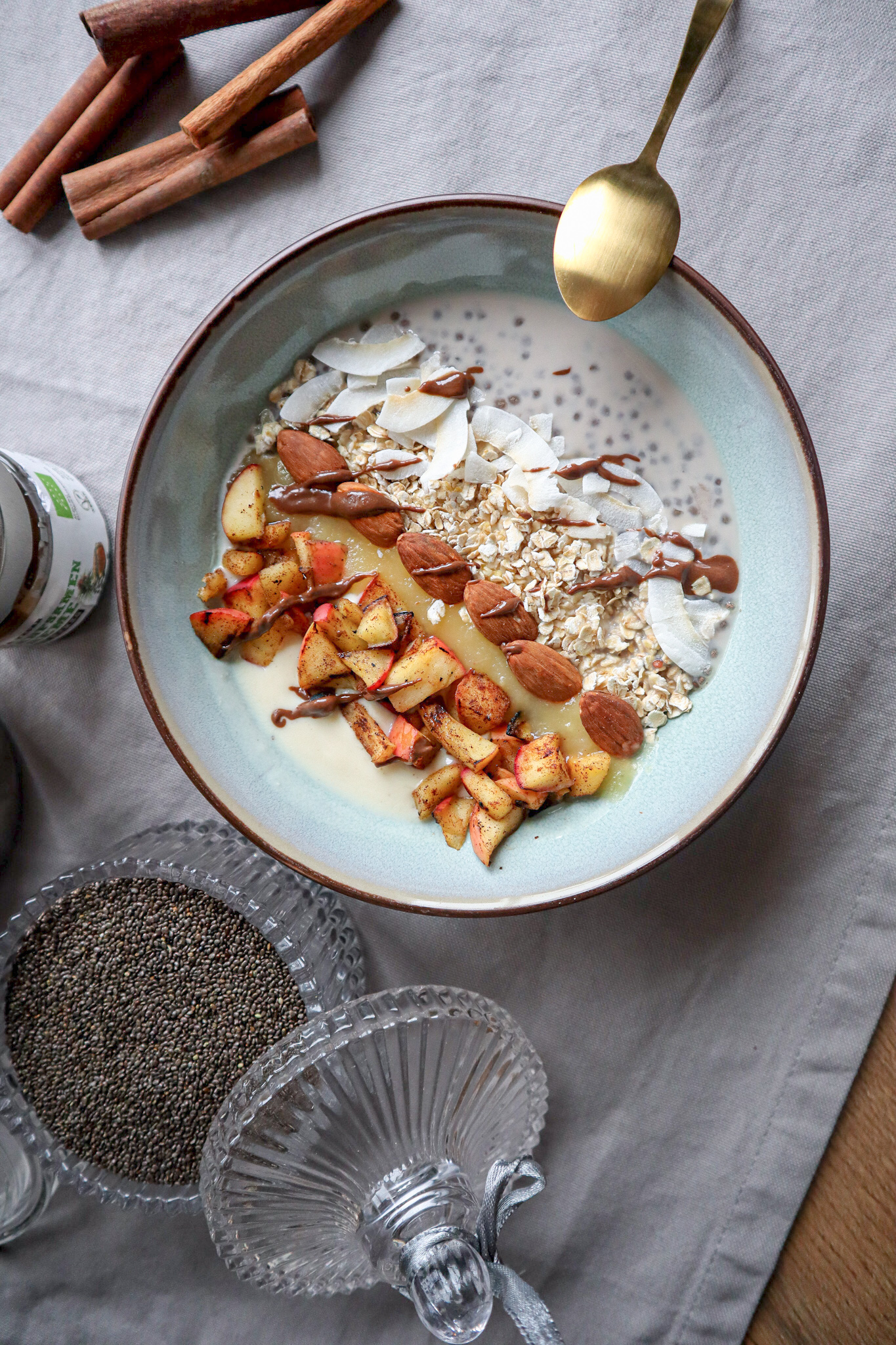Frühstücksbowl mit Chia, Haferflocken, Zimtapfel, Kokoschips und Mandeln von oben