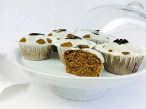 Muffins mit heller Glasur und Kürbiskernen auf einer Kuchenplatte