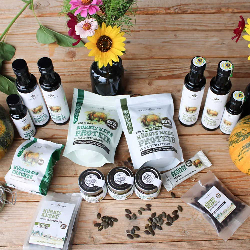 A variety of organic products from Schalk Mühle featuring oils, pumpkin seed protein, kernels, and flowers as gift ideas