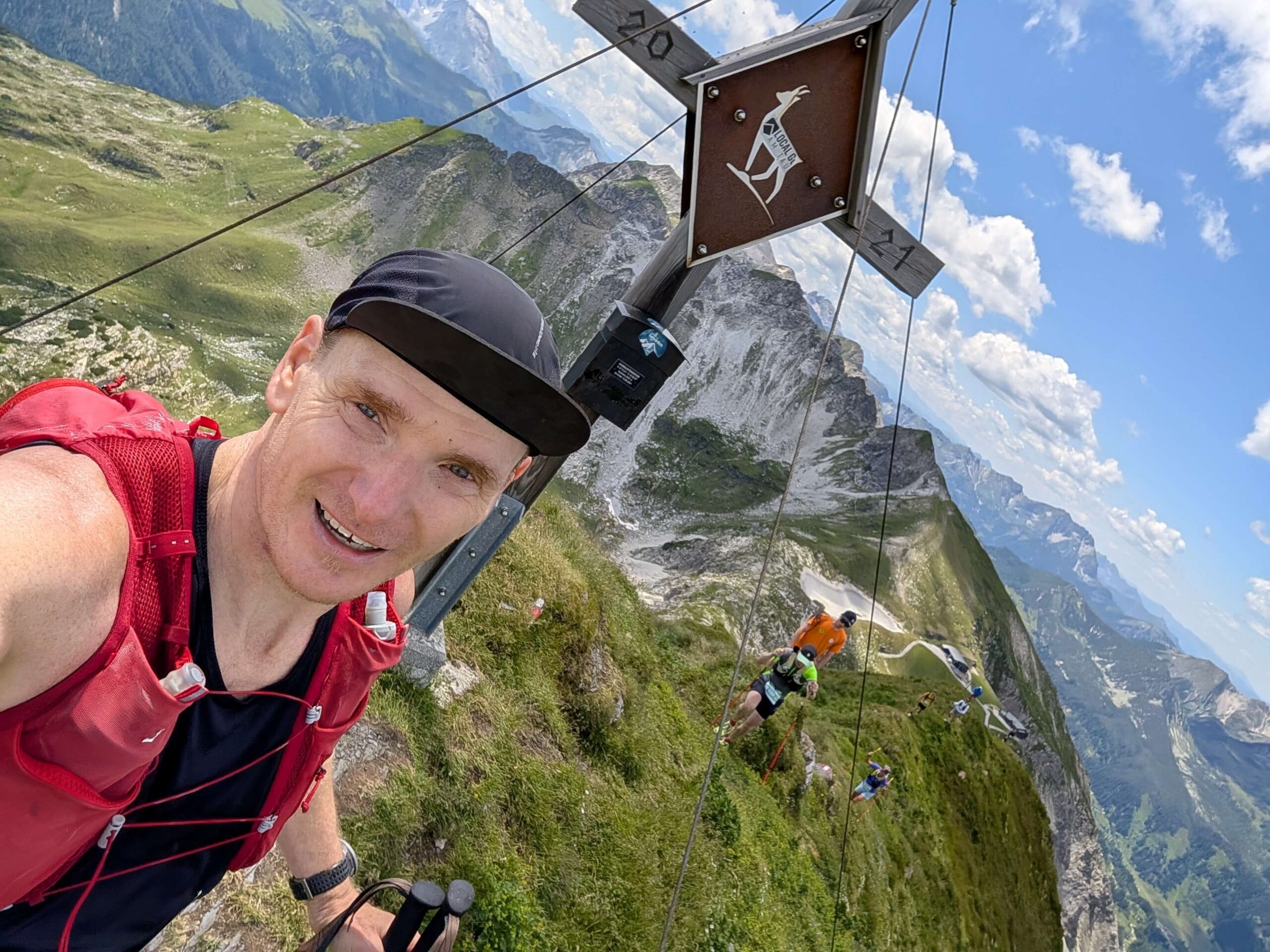 Bio-Partner-Landwirt Karl Schodl mit Gipfelkreuz im Hintergrund während des OTS Obertauern Trailrun Summit.
