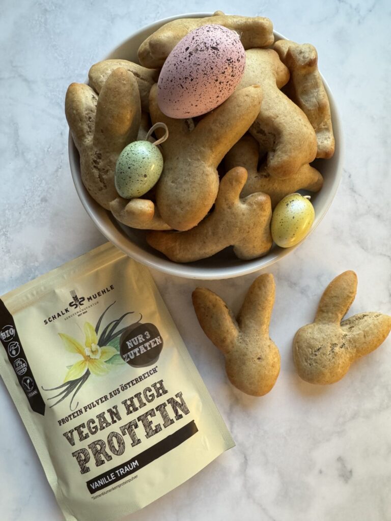 Hasenförmiges Ostergebäck in Schale mit bunten Deko-Eiern und Schalk Mühle Vanille-Proteinpulver