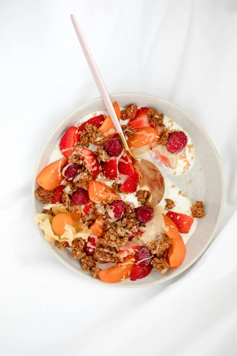 Frühstücksbowl mit Joghurt, Erdbeeren, Himbeeren, Marille und Granola von oben