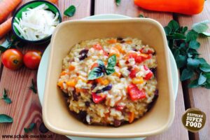 Cremiges Risotto mit rotem Paprika, Kidneybohnen und frischem Basilikum in einer Schale