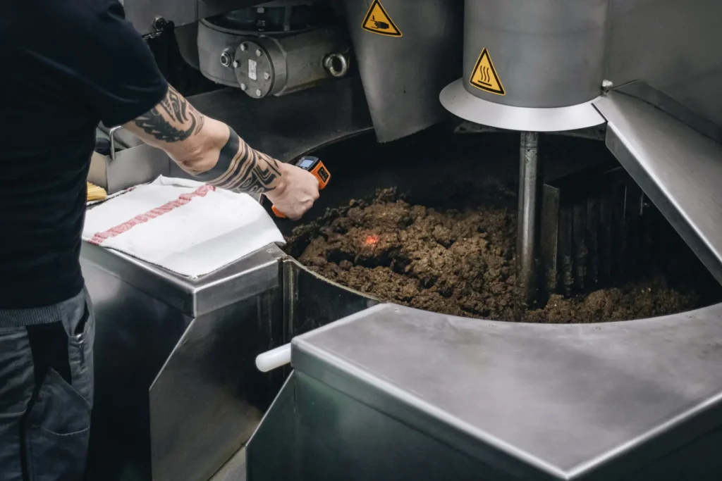 Employee measures the temperature at the oil press with an infrared thermometer