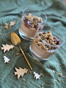 Schoko-Zimt-Pudding mit Weichseln und Streusel in zwei Gläsern, weihnachtlich dekoriert