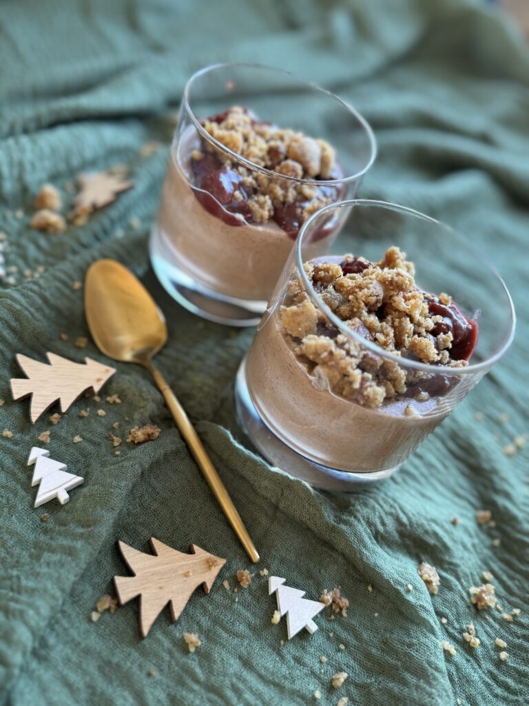 Schoko-Zimt-Pudding mit Weichseln und Streusel in zwei Gläsern, weihnachtlich dekoriert