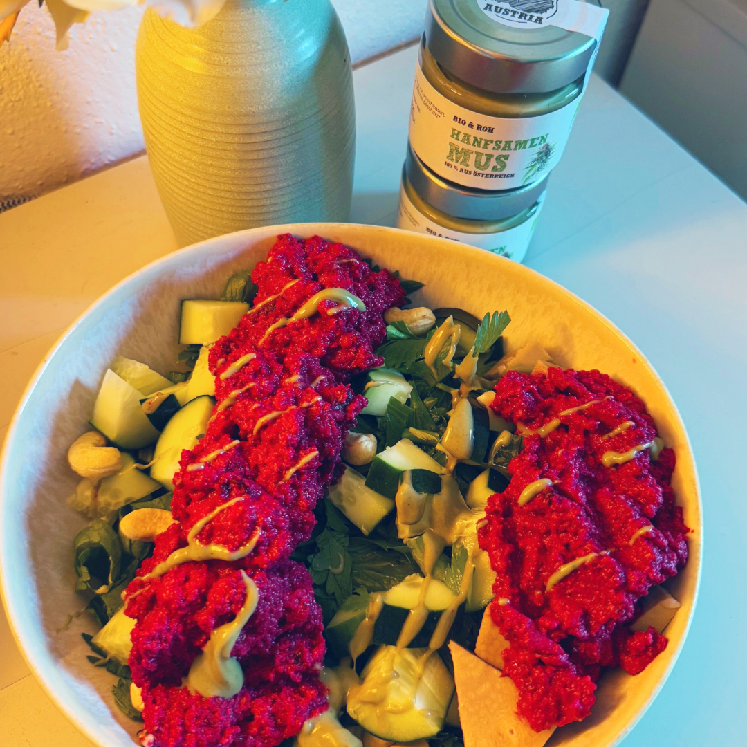 Bunte Bowl mit Rote-Rüben-Aufstrich, Gurke und Avocado neben Schalk Mühle Hanfsamen-Mus
