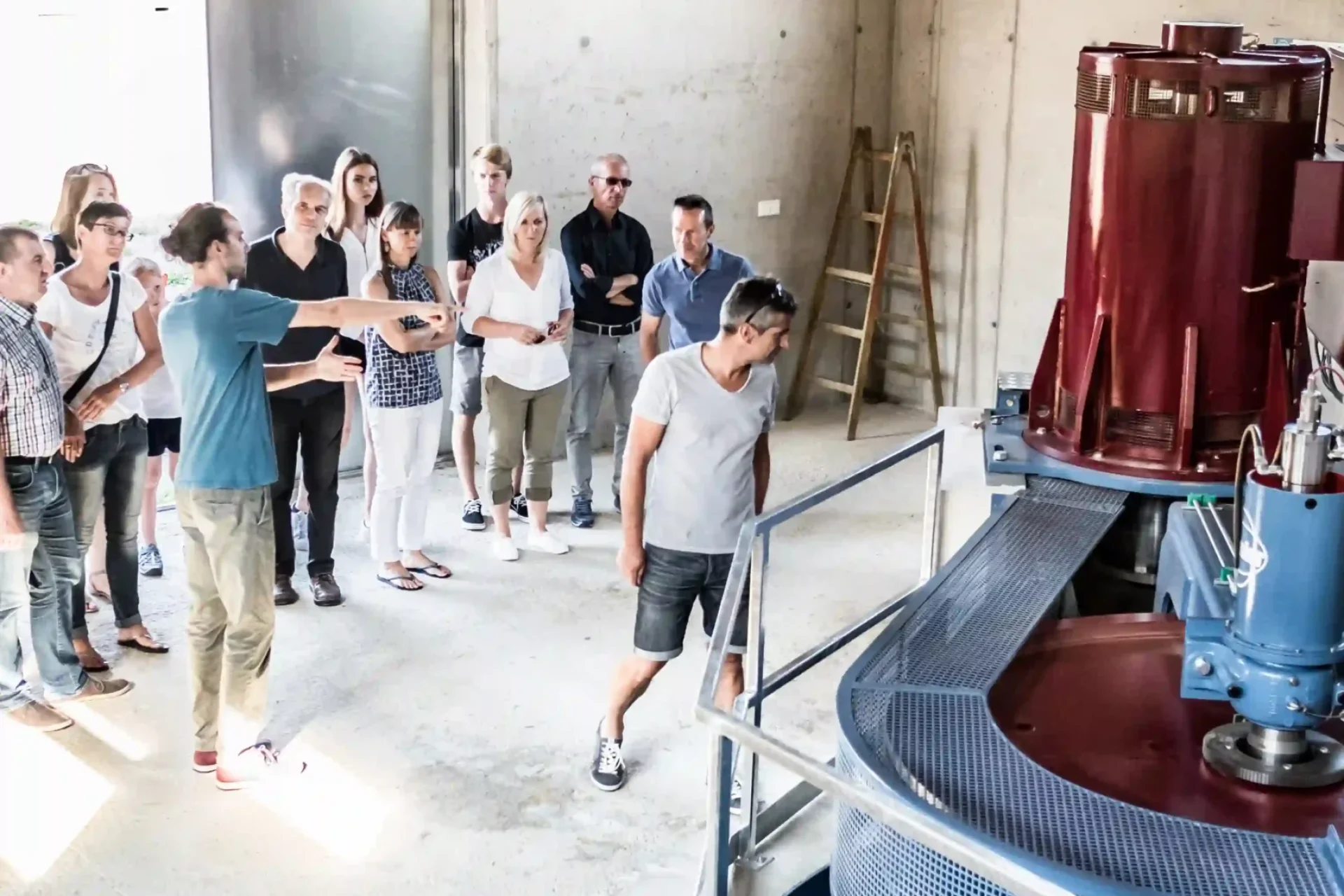 Besuchergruppe betrachtet bei einer Führung die moderne Turbine im Wasserkraftwerk der Schalk Mühle