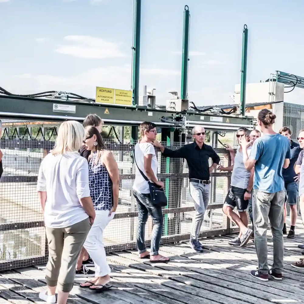 Besuchergruppe bei einer Führung an der automatischen Rechenanlage des Wasserkraftwerks der Schalk Mühle