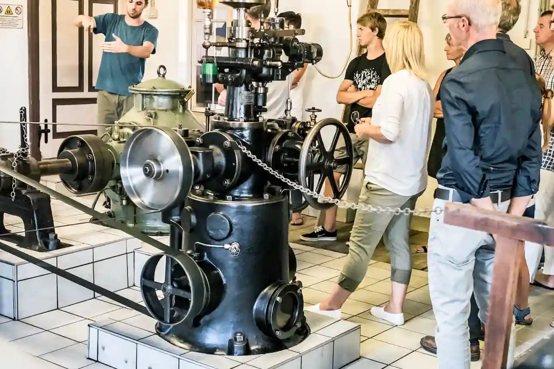Guide erklärt einer Besuchergruppe die historische Turbine im alten Wasserkraftwerk der Schalk Mühle
